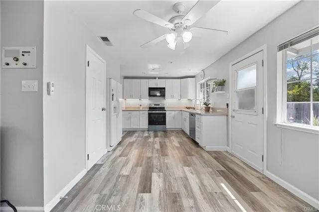 a view of kitchen with wooden floor and electronic appliances