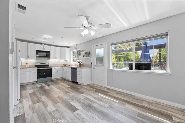 a kitchen with white cabinets and appliances
