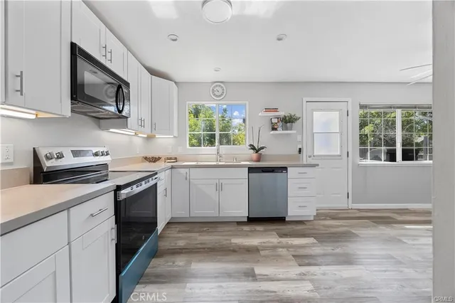 a kitchen with stainless steel appliances granite countertop a stove a sink and a microwave