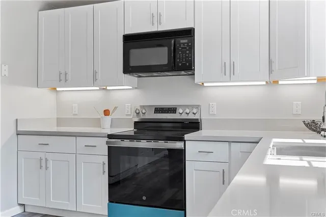 a kitchen with white cabinets and appliances