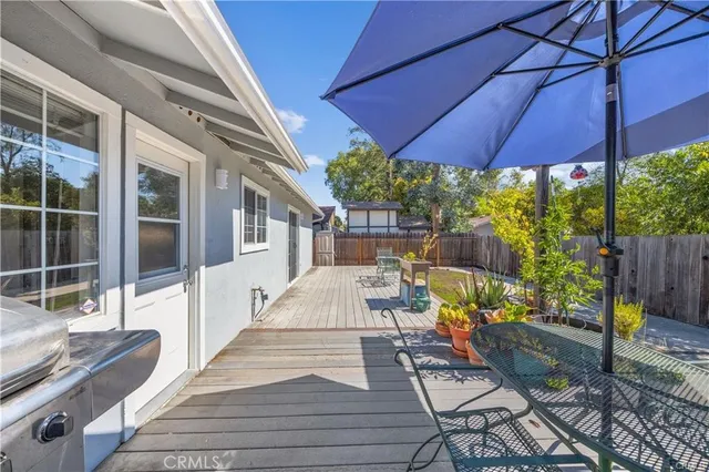 a view of a patio with table and chairs under an umbrella