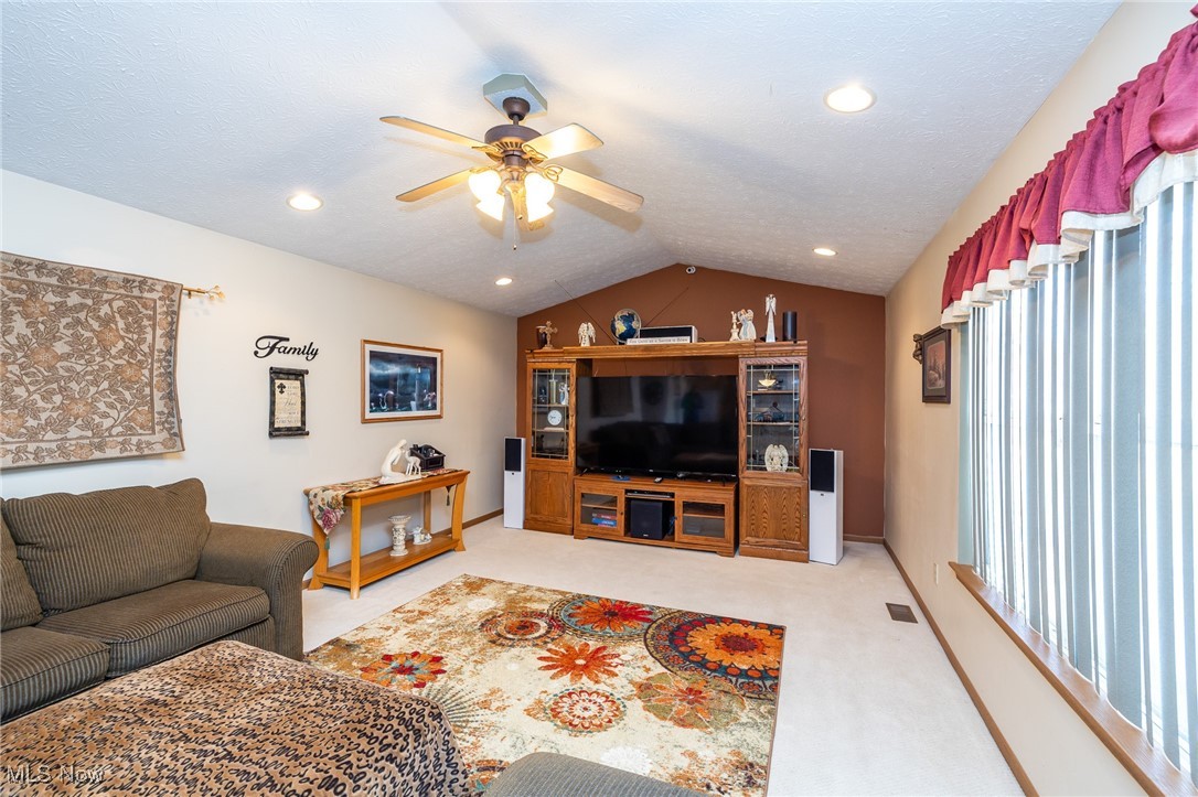 12181 Williams Road Homerville, OH 44235 - Photo 8 of 49 Living room featuring lofted ceiling, light carpet, and ceiling fan
