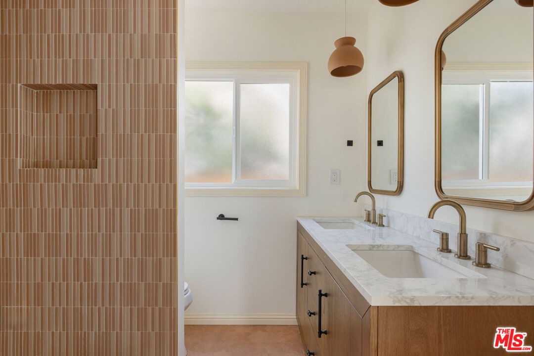 347 North Rampart Boulevard Los Angeles, CA 90026 - Photo 12 of 24 a bathroom with a granite countertop sink and a mirror
