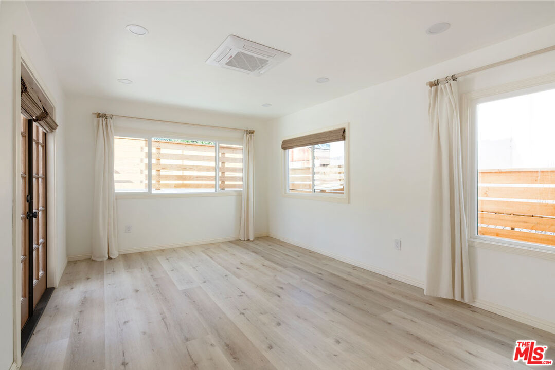 347 North Rampart Boulevard Los Angeles, CA 90026 - Photo 16 of 24 a view of an empty room with wooden floor and a window