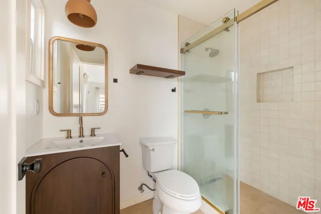 a bathroom with a granite countertop sink toilet and shower