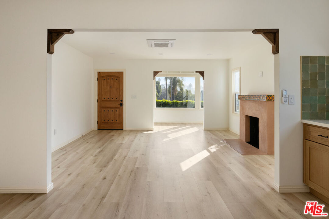 347 North Rampart Boulevard Los Angeles, CA 90026 - Photo 7 of 24 a view of empty room with wooden floor and fireplace