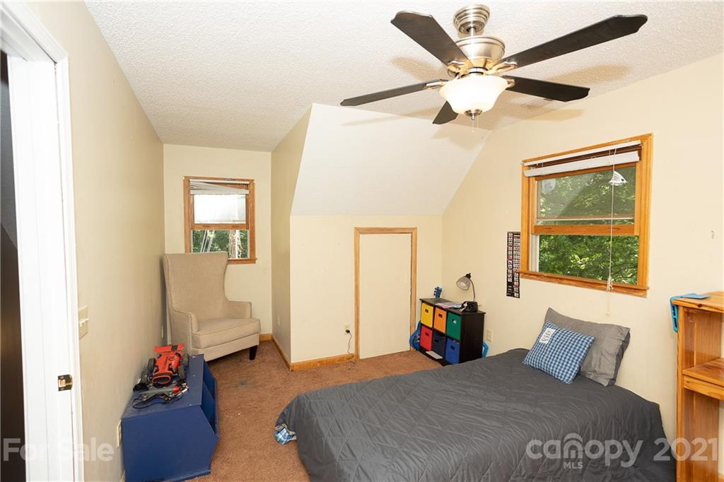 507 Vision Road Canton, NC 28716 - Photo 20 of 39 a bedroom with a bed and a chandelier