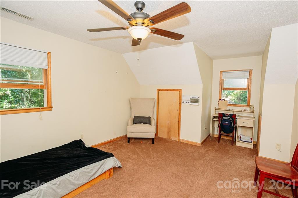 507 Vision Road Canton, NC 28716 - Photo 25 of 39 a bedroom with a bed and a chandelier