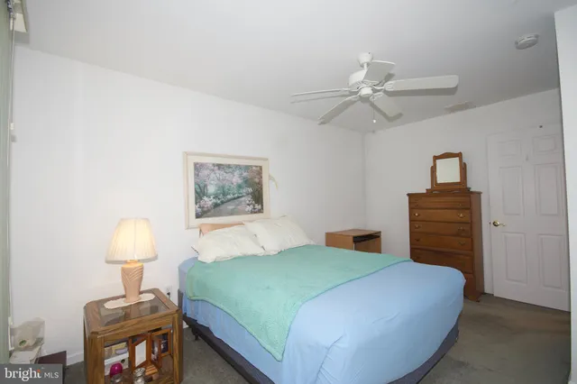 a bedroom with a bed and a lamp on the dresser