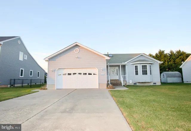 a view of a house with a yard and large tree