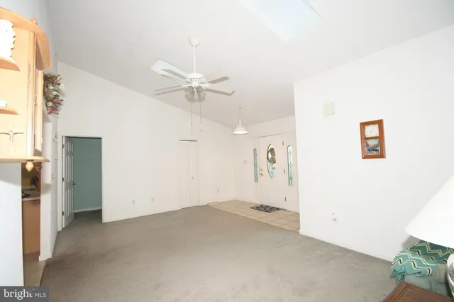 an empty room with a ceiling fan and window