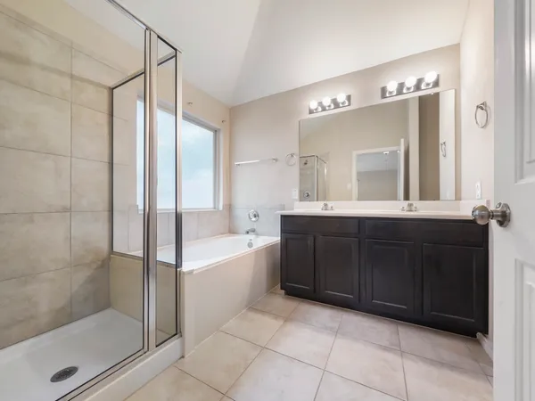 a bathroom with a bathtub shower sink and mirror