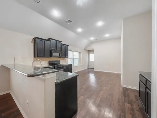 a kitchen with stainless steel appliances granite countertop a sink stove and cabinets