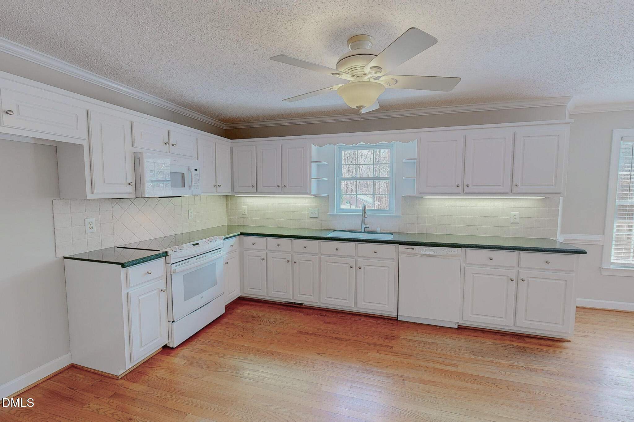 202 Equestrian Chase Rougemont, NC 27572 - Photo 15 of 54 a kitchen with granite countertop white cabinets a sink dishwasher and a stove with wooden floor