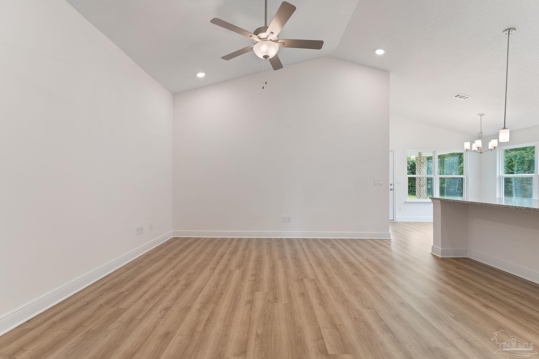 4930 East Spencer Field Road Pace, FL 32571 - Photo 11 of 28 an empty room with wooden floor and windows