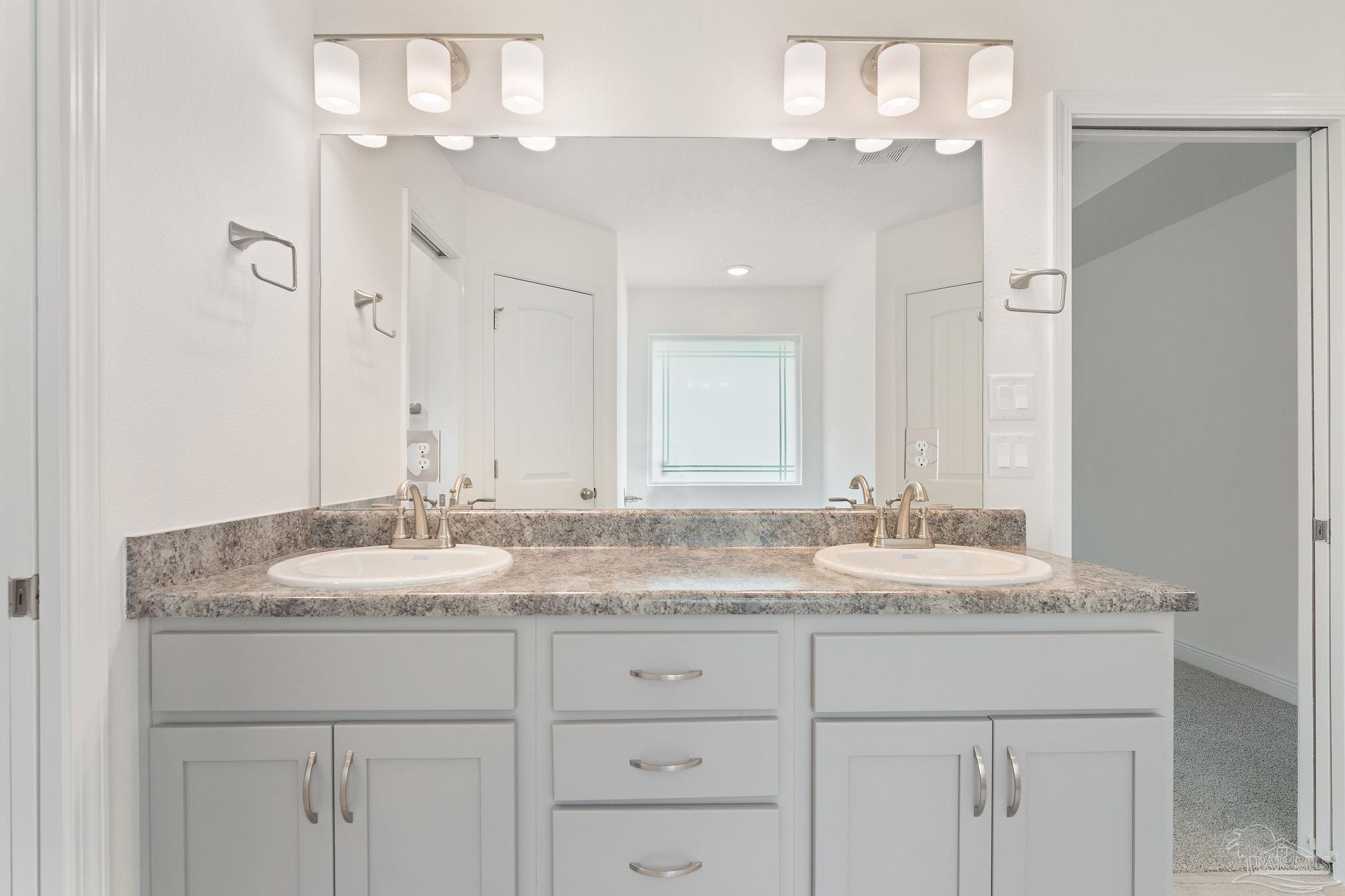 4930 East Spencer Field Road Pace, FL 32571 - Photo 17 of 28 a bathroom with a granite countertop double vanity sinks a vanity and a light fixture