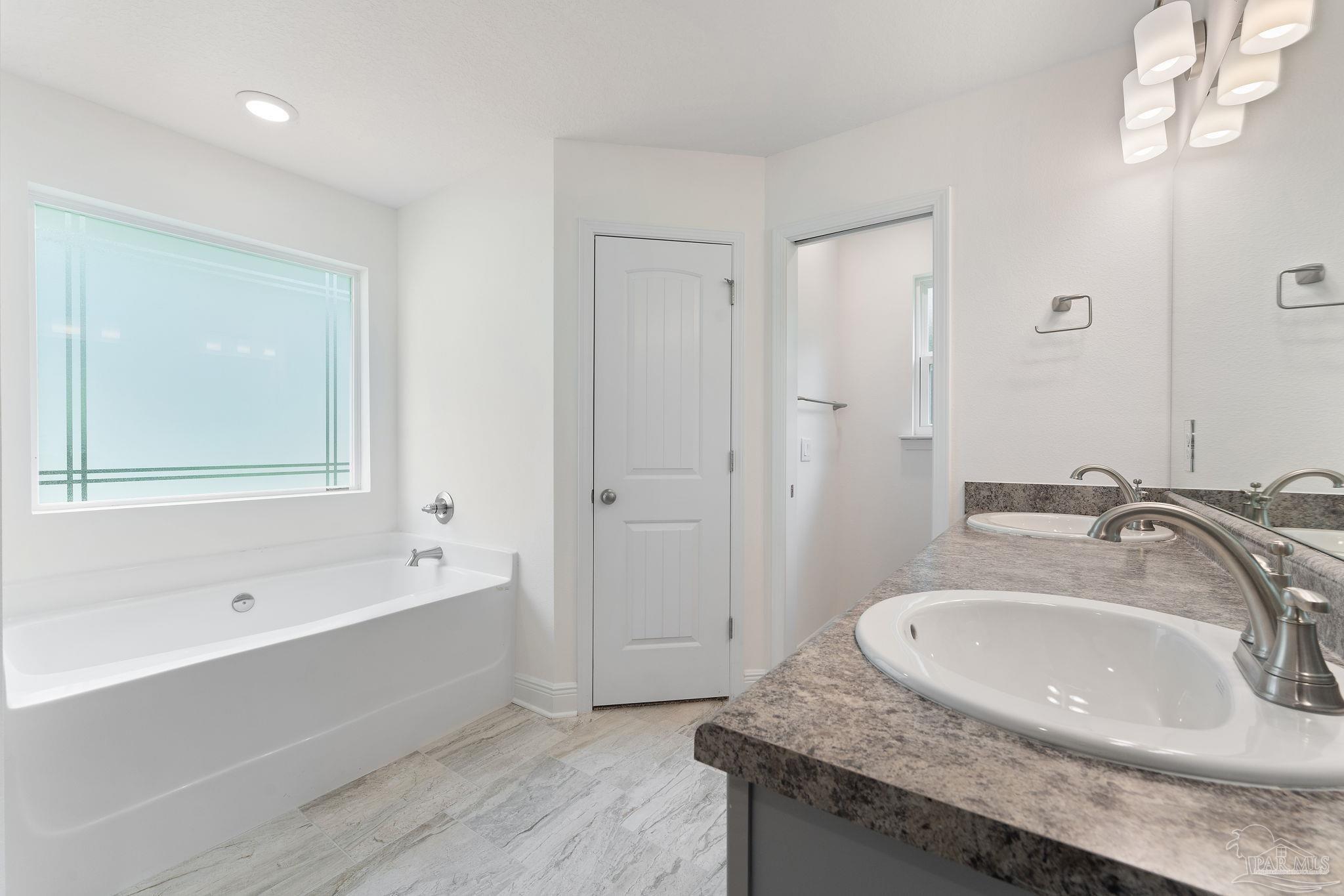 4930 East Spencer Field Road Pace, FL 32571 - Photo 18 of 28 a bathroom with a granite countertop tub sink and mirror