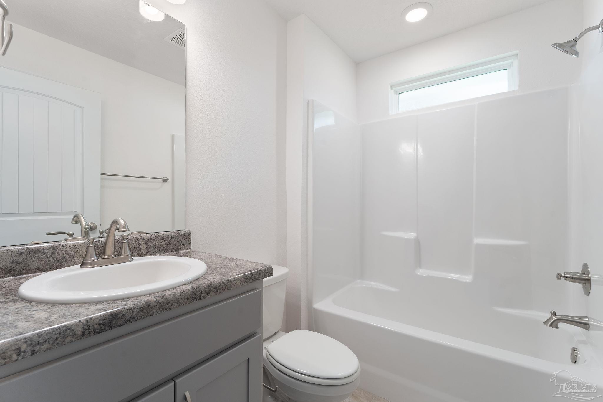 4930 East Spencer Field Road Pace, FL 32571 - Photo 19 of 28 a bathroom with a granite countertop sink toilet and bathtub