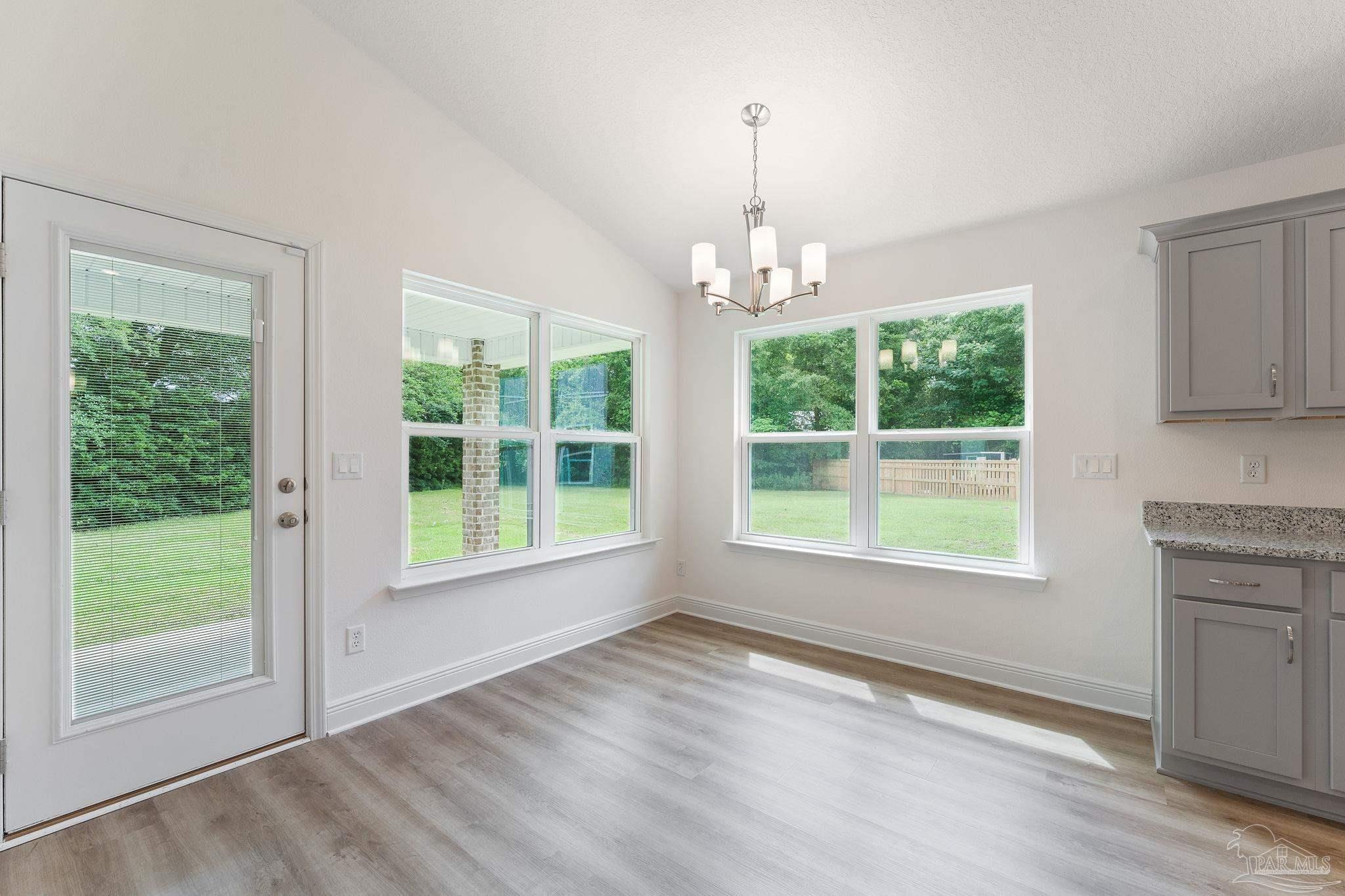 4930 East Spencer Field Road Pace, FL 32571 - Photo 9 of 28 a view of an empty room with a window and wooden floor