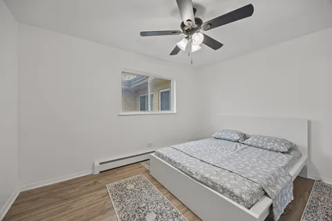 a bedroom with a bed and a chandelier fan