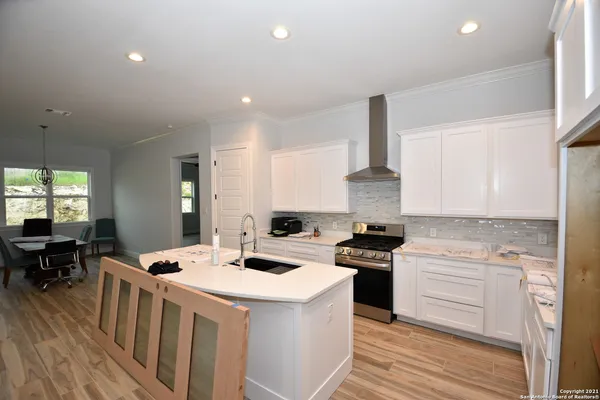 a kitchen that has a lot of cabinets in it and wooden floors