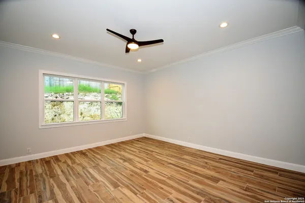 an empty room with a window and a ceiling fan