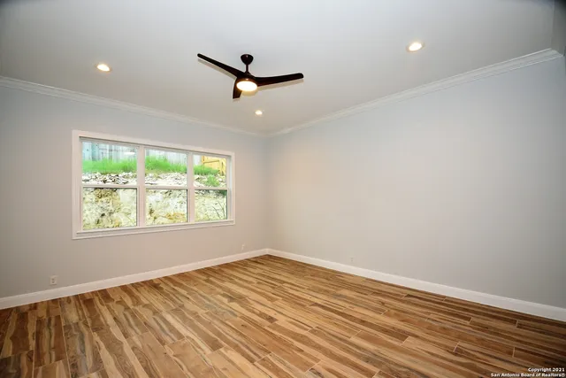 an empty room with a window and a ceiling fan