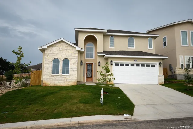a front view of a house with a yard and garage