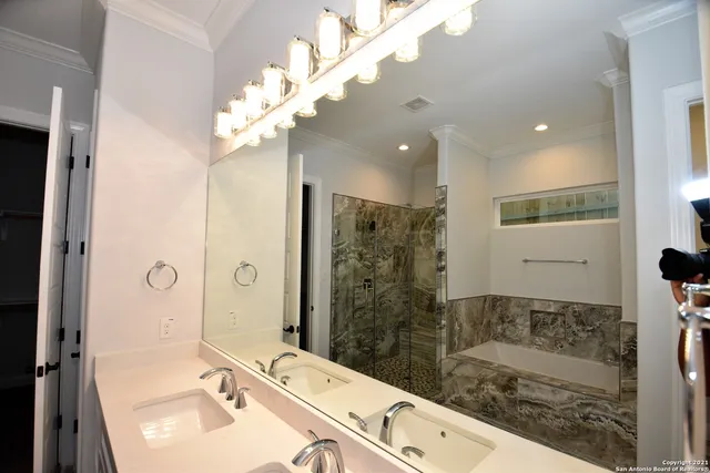 a bathroom with a sink mirror and a shower