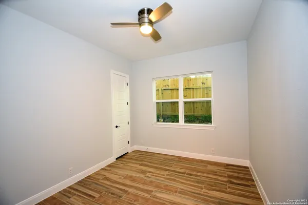 a view of empty room with wooden floor