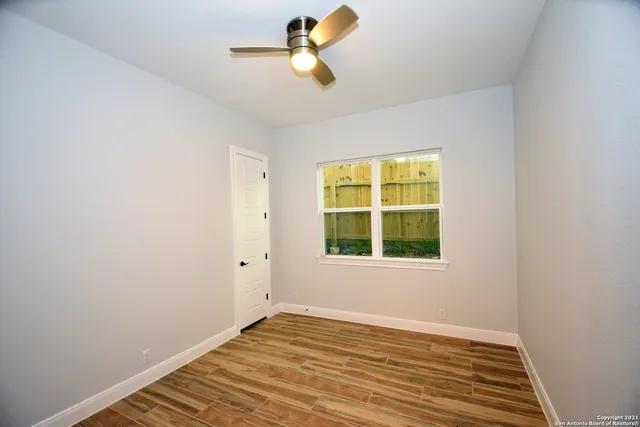 a view of empty room with wooden floor