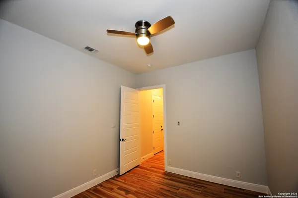 a view of a hallway with wooden floor and entryway