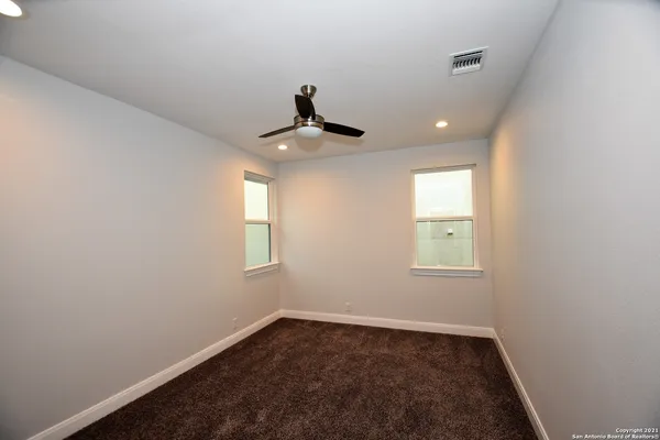 an empty room with closet and windows