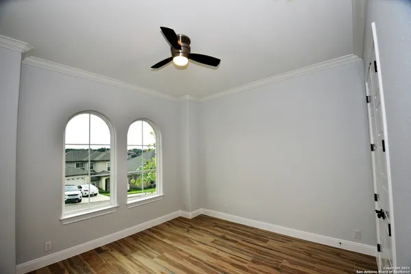 a view of empty room with window and wooden floor
