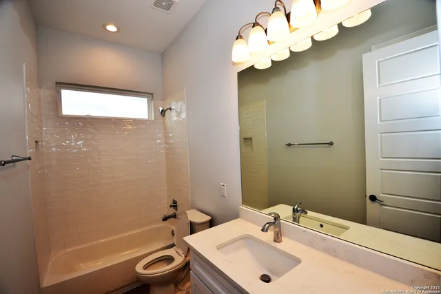 a bathroom with a sink a tub and a mirror