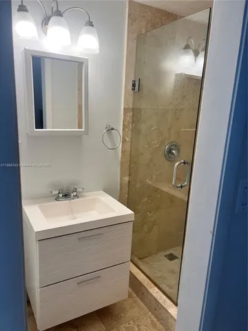a bathroom with a sink a toilet a mirror and shower