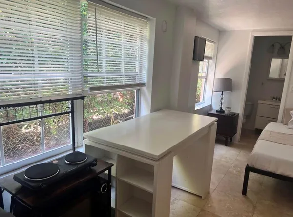 a view of a dining room with furniture and large windows