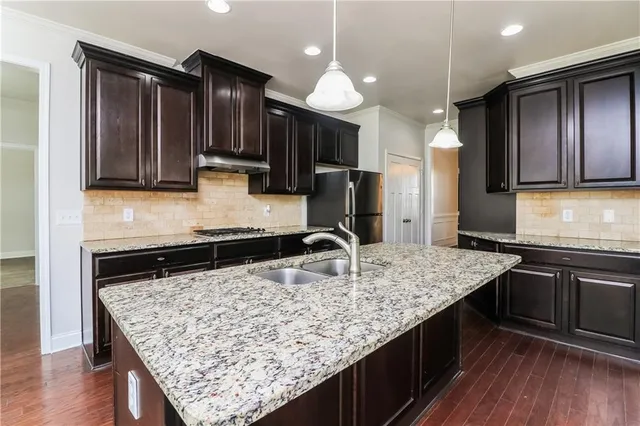 a kitchen with kitchen island granite countertop wooden cabinets counter top space and stainless steel appliances