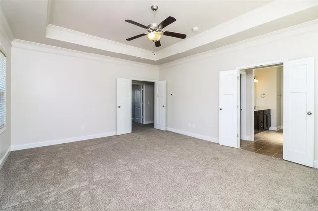 an empty room with closet and a ceiling fan