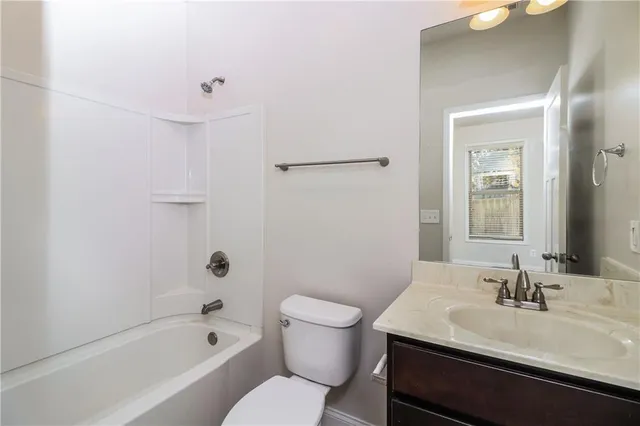 a bathroom with a sink toilet vanity and tub