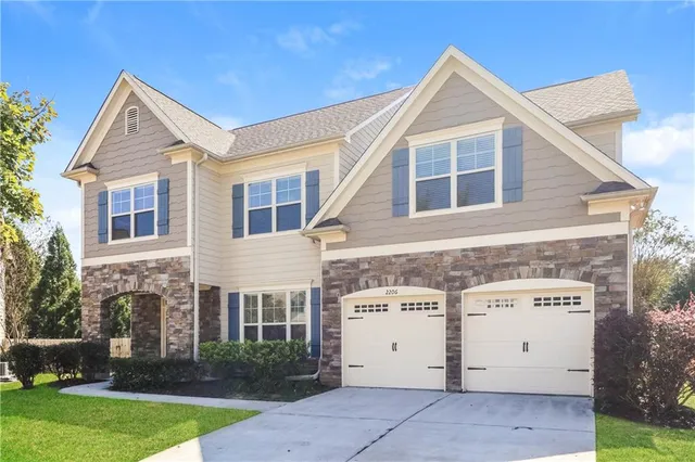 a view of a house with a yard and a garage