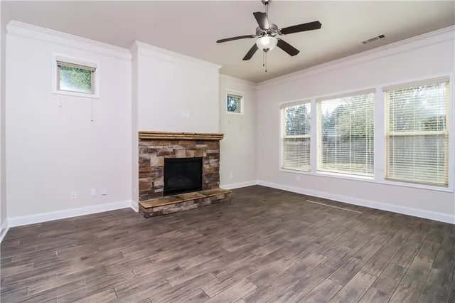 a view of empty room with wooden floor and fireplace