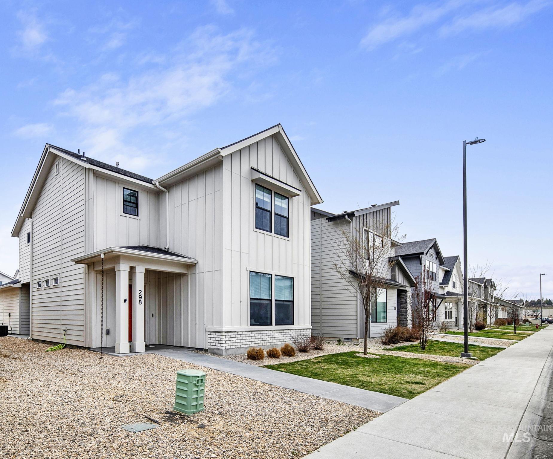 298 South Fritts Avenue Meridian, ID 83642 - Photo 2 of 32 View of front of property featuring board and batten siding, a residential view, and a front lawn