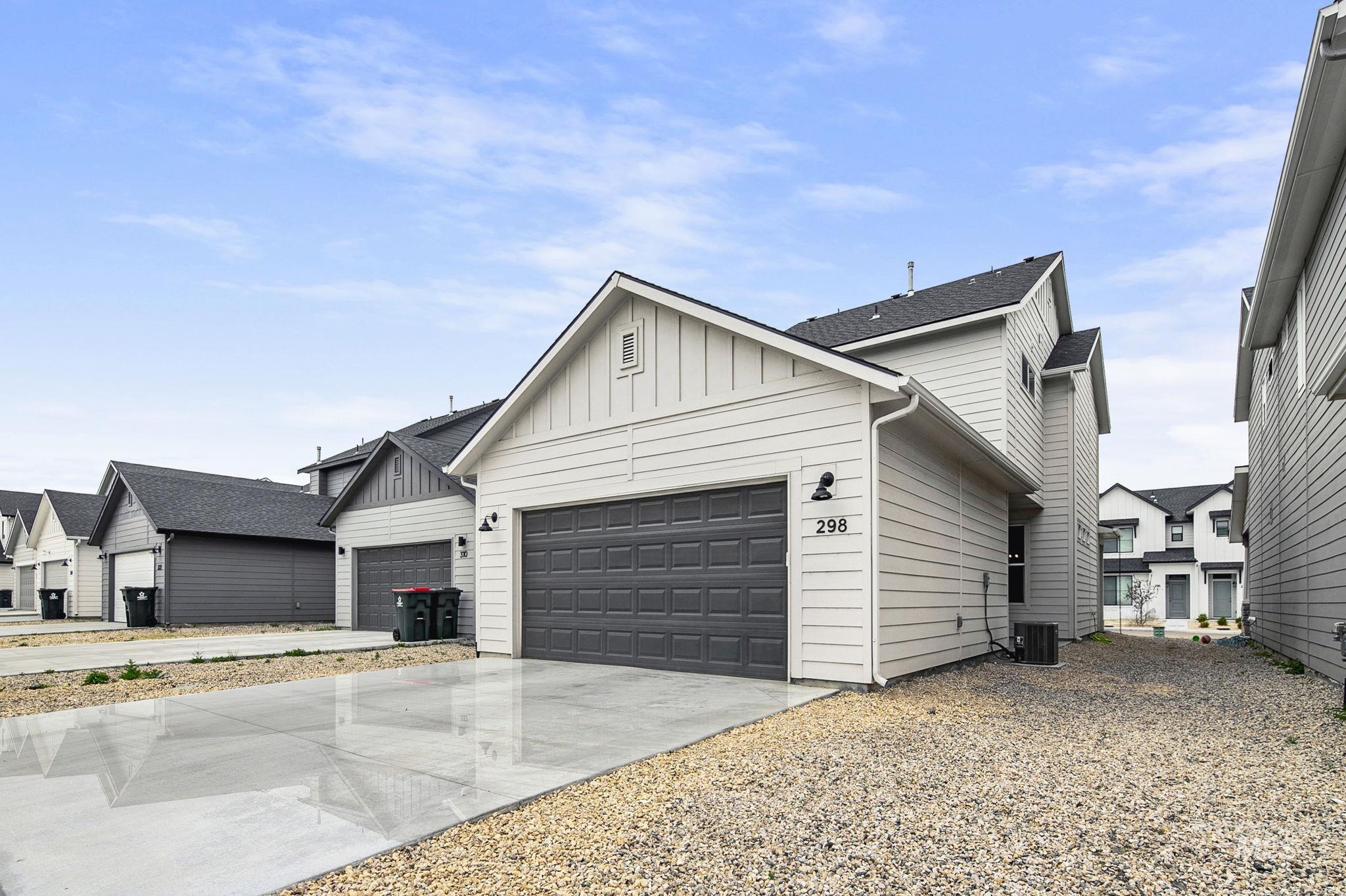 298 South Fritts Avenue Meridian, ID 83642 - Photo 30 of 32 View of front of home featuring board and batten siding, concrete driveway, an attached garage, and a residential view