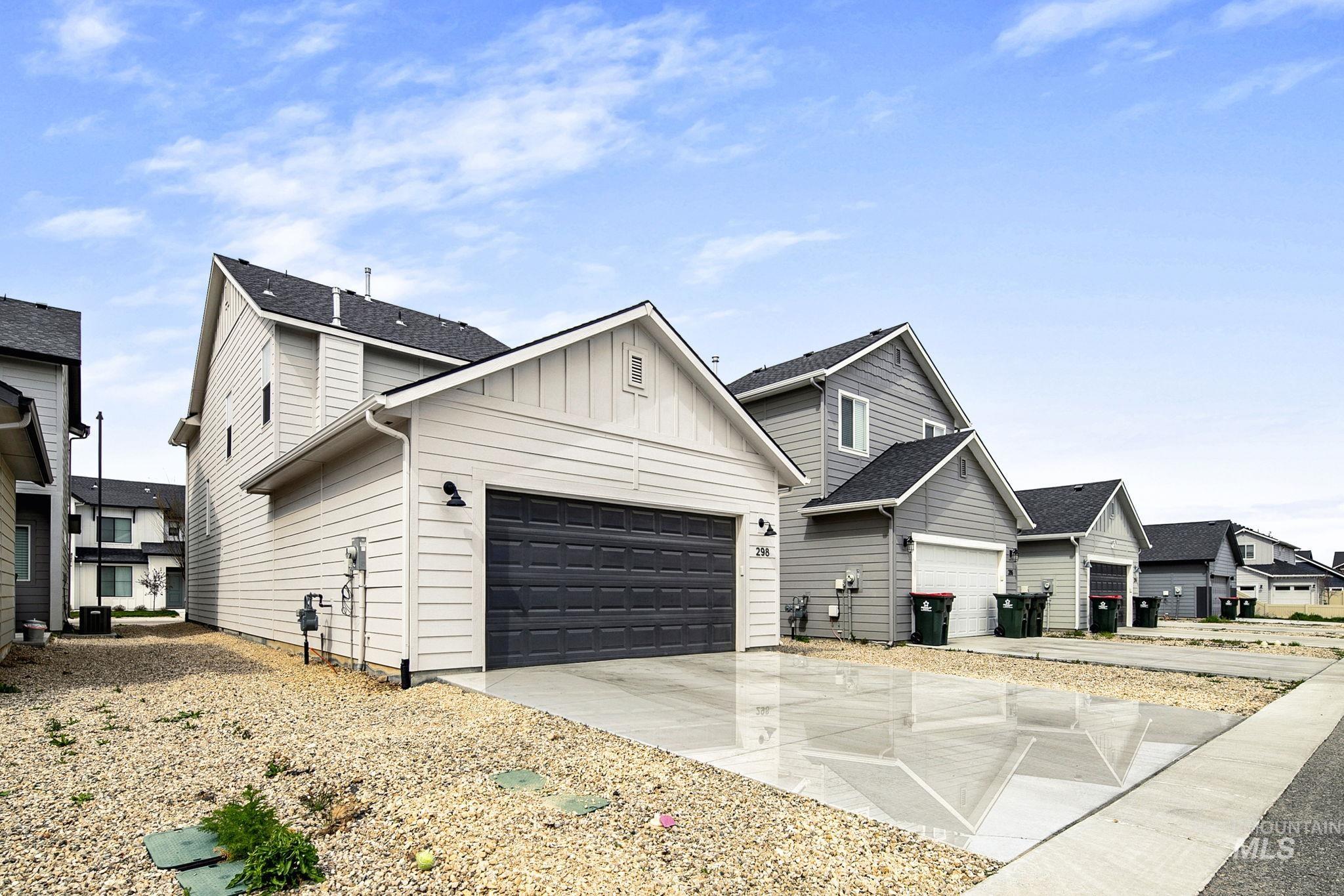 298 South Fritts Avenue Meridian, ID 83642 - Photo 31 of 32 View of front of home featuring board and batten siding, concrete driveway, an attached garage, a residential view, and roof with shingles