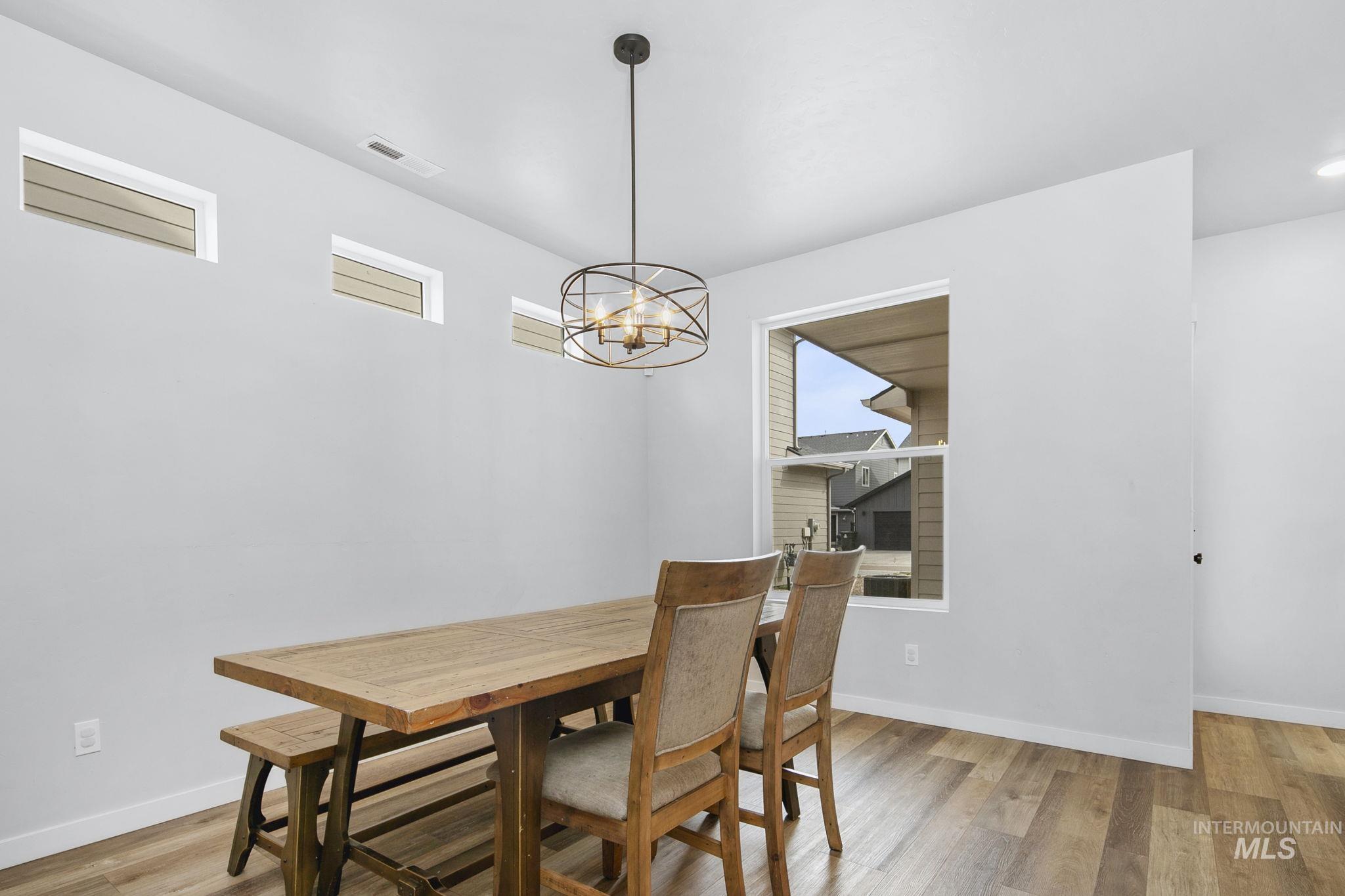 298 South Fritts Avenue Meridian, ID 83642 - Photo 8 of 32 Dining space with light wood-style floors, hanging lights, and a fireplace