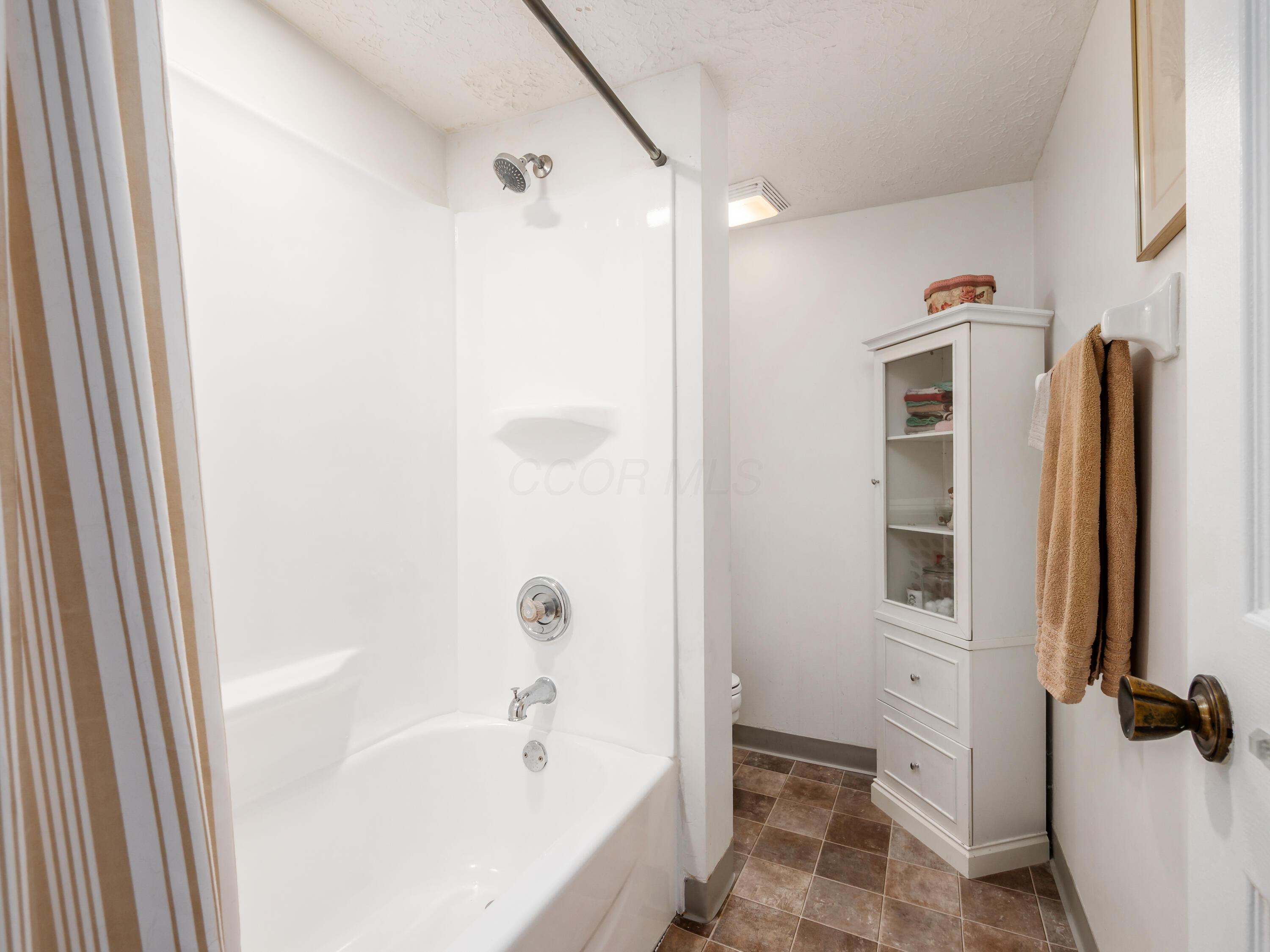 7004 Avery Road Dublin, OH 43017 - Photo 23 of 31 New bath/shower installed August, 2025. New valves and fixtures also. The toilet is tucked back beside the shower for privacy.