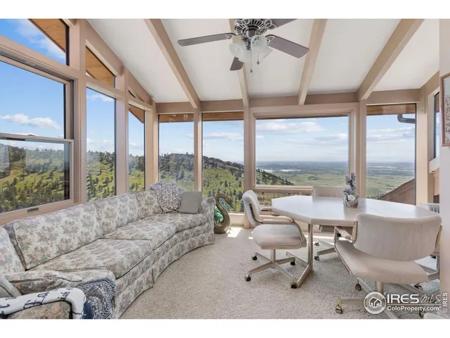 a living room with furniture and floor to ceiling windows