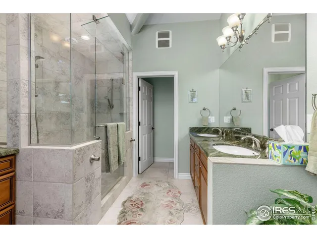 a bathroom with a sink vanity granite shower and a mirror