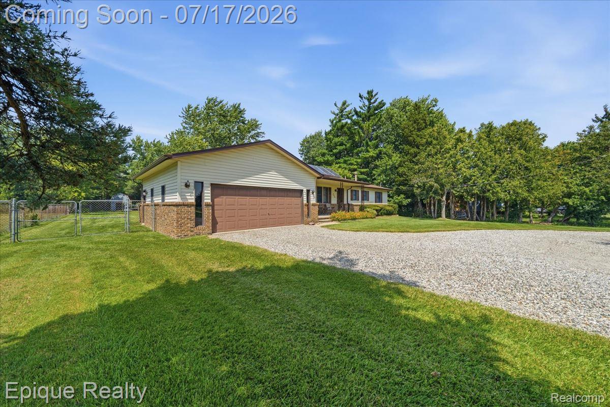 555 East Square Lake Road Troy, MI 48085 - Photo 3 of 48 Ranch-style residence featuring a prominent gravel driveway and a two-car attached garage with a brown door